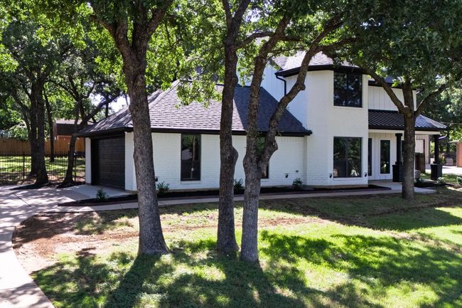 View of front facade featuring concrete driveway, a garage, brick siding, and a shingled roof | Image 4