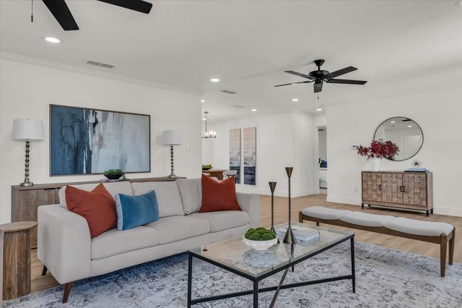 Living room featuring visible vents, ceiling fan with notable chandelier, crown molding, and wood finished floors | Image 14