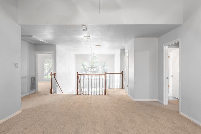 Unfurnished room with carpet floors, baseboards, and a chandelier | Image 24