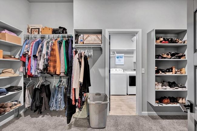 Spacious closet featuring washer and clothes dryer and carpet floors | Image 33