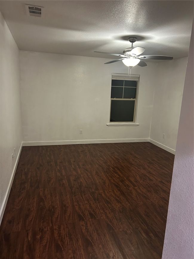 Unfurnished room featuring wood finished floors, a ceiling fan, and a textured ceiling | Image 18