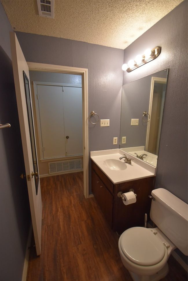 Half bath featuring wood finished floors, vanity, and a textured ceiling | Image 13