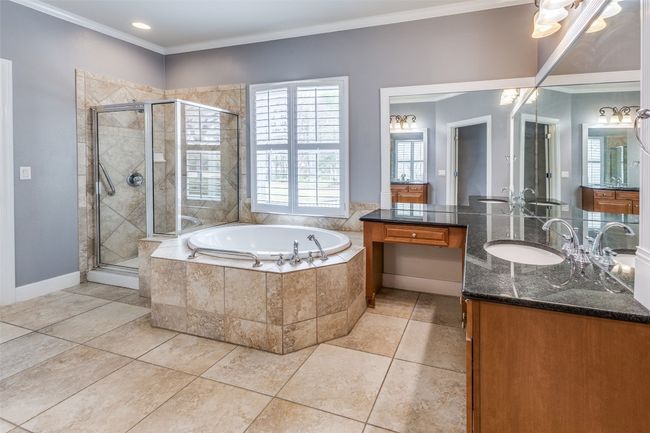 Bathroom featuring tile patterned floors, ornamental molding, a garden tub, and a shower stall | Image 14
