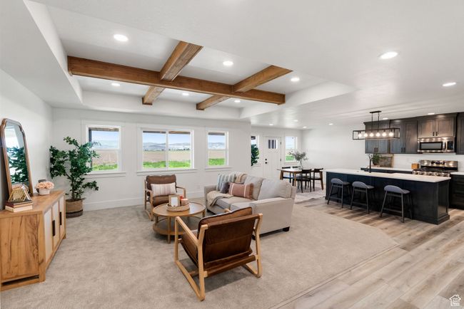 Living area featuring healthy amount of natural light, coffered ceiling, light wood-style flooring, recessed lighting, and beamed ceiling | Image 5