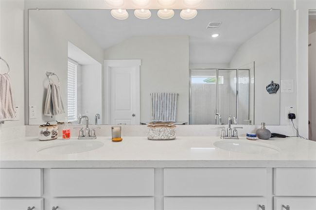 Bathroom featuring double vanity, a stall shower, and lofted ceiling | Image 23