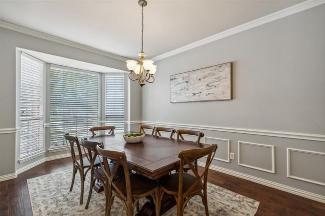 Dining room featuring ornamental molding, plenty of natural light, a chandelier, and dark hardwood / wood-style floors | Image 4