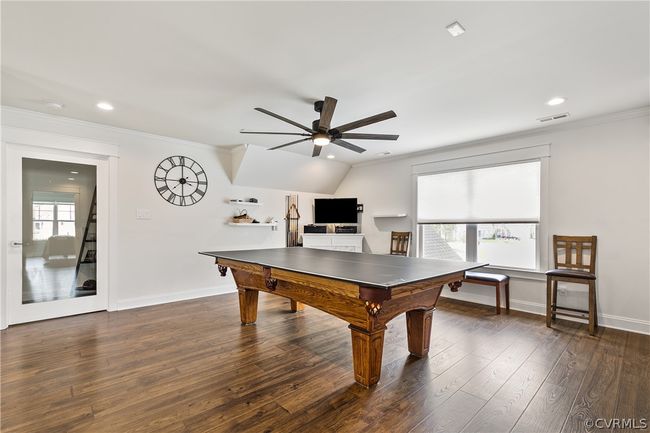 Game room featuring ornamental molding, ceiling fan, and dark wood-type flooring | Image 27