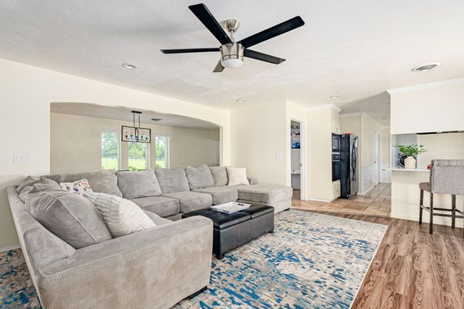 Living area with arched walkways, light wood-style floors, ceiling fan, recessed lighting, and baseboards | Image 27