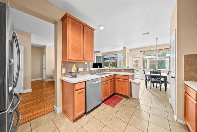 Kitchen with appliances with stainless steel finishes, a sink, a peninsula, and light countertops | Image 24