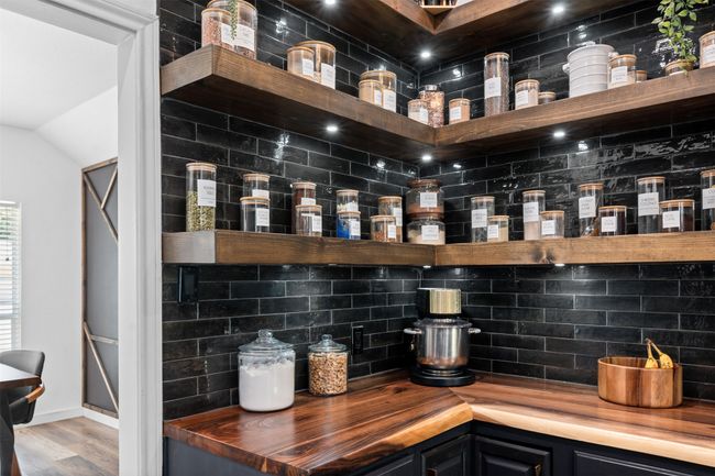 Bar with tasteful backsplash, wooden counters, and light hardwood / wood-style floors | Image 6