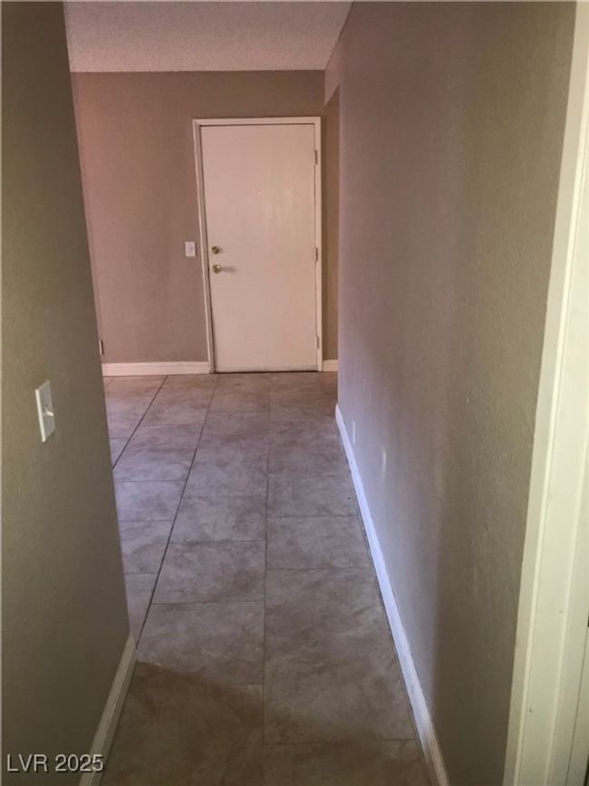 Hallway featuring baseboards and a textured ceiling | Image 6