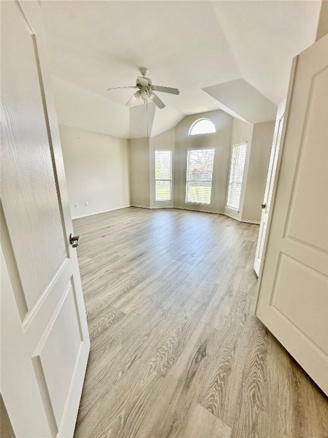 Unfurnished room featuring a ceiling fan, vaulted ceiling, and light wood finished floors | Image 12
