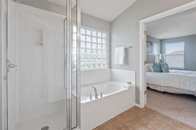 Bathroom with ensuite bath, a stall shower, a garden tub, and tile patterned flooring | Image 32