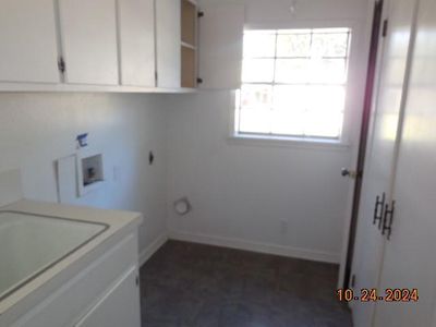 Clothes washing area featuring cabinets, hookup for an electric dryer, and washer hookup | Image 3