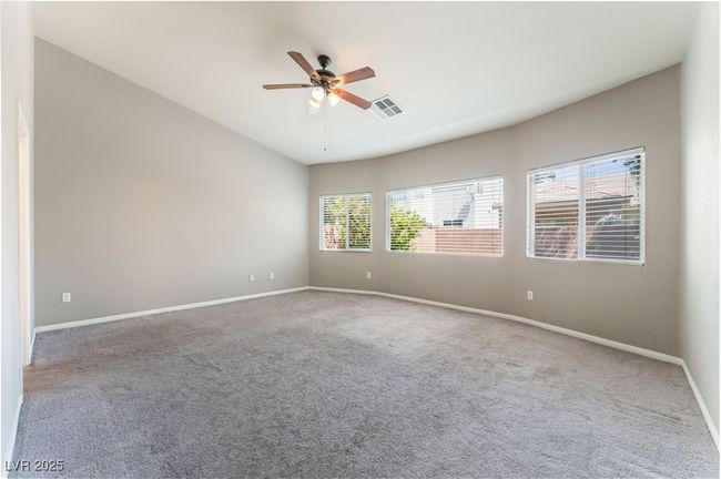 Carpeted spare room with a ceiling fan, baseboards, and lofted ceiling | Image 26