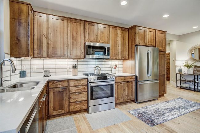 Kitchen featuring recessed lighting, a sink, decorative backsplash, stainless steel appliances, and light wood-style floors | Image 10