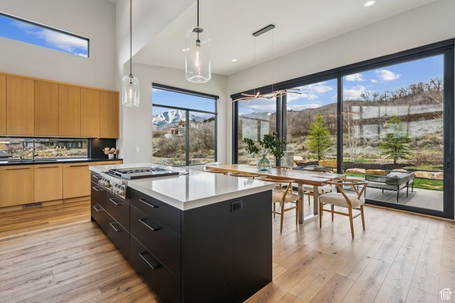 Kitchen featuring modern cabinets, stainless steel gas cooktop, a mountain view, and light wood-type flooring | Image 25
