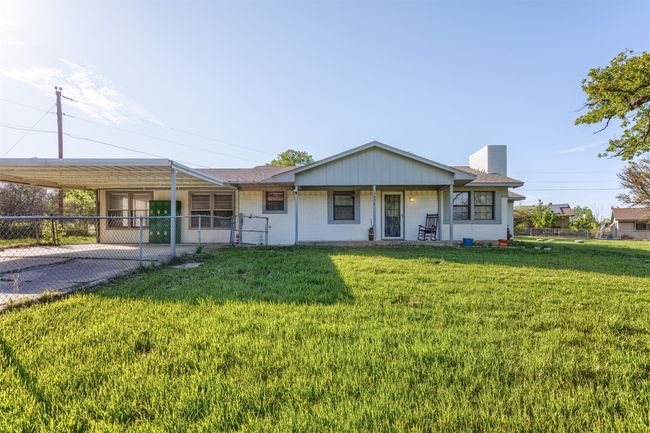 View of front of home featuring a carport, a chimney, fence, brick siding, and a front yard | Image 30