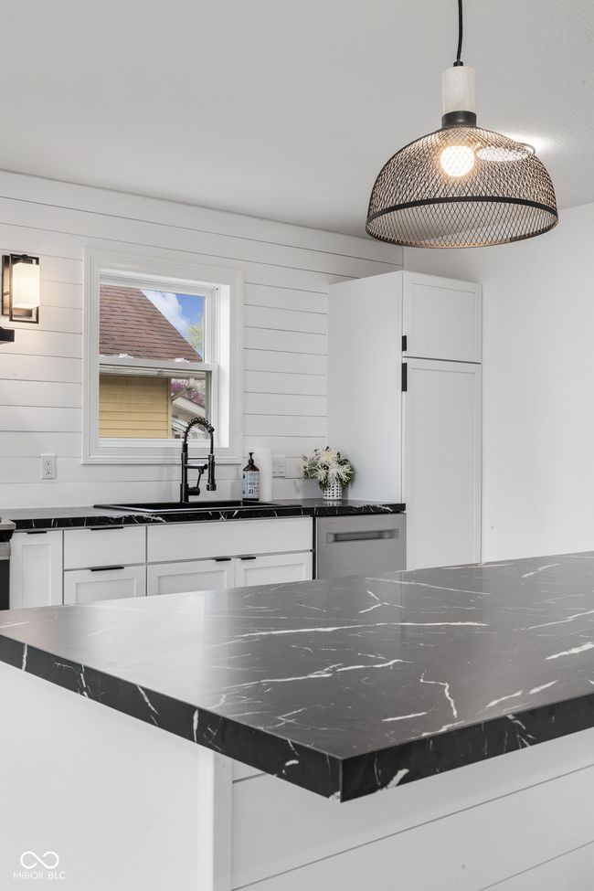 details with white cabinets, hanging light fixtures, stainless steel dishwasher, and a sink | Image 25