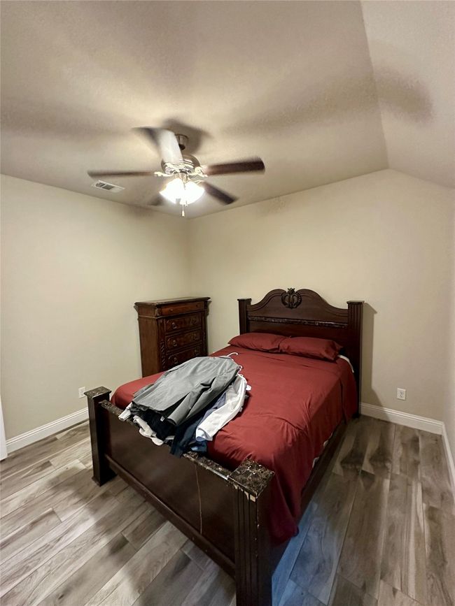 Bedroom featuring wood finished floors, lofted ceiling, and ceiling fan | Image 24