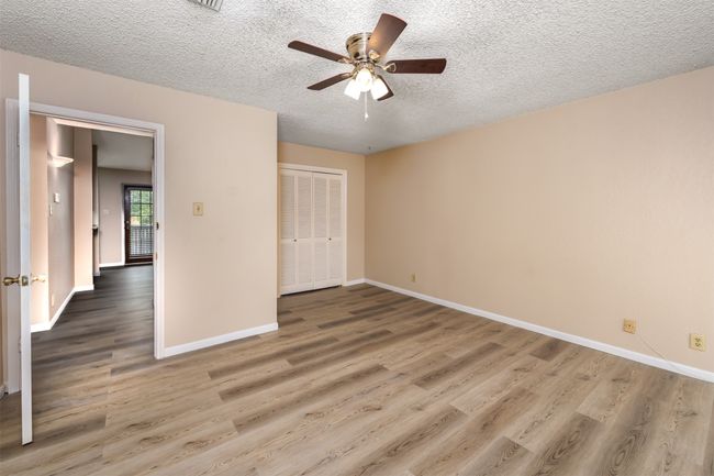 Unfurnished bedroom with baseboards, wood finished floors, a textured ceiling, and a closet | Image 7