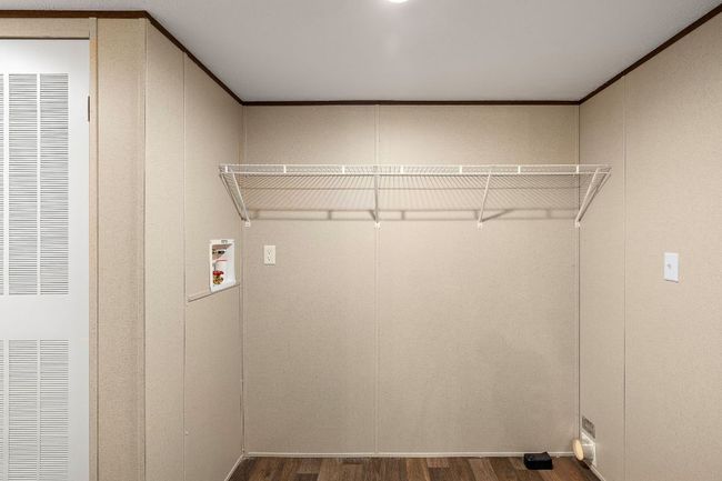 Washroom with dark wood-type flooring, washer hookup, a heating unit, and laundry area | Image 32