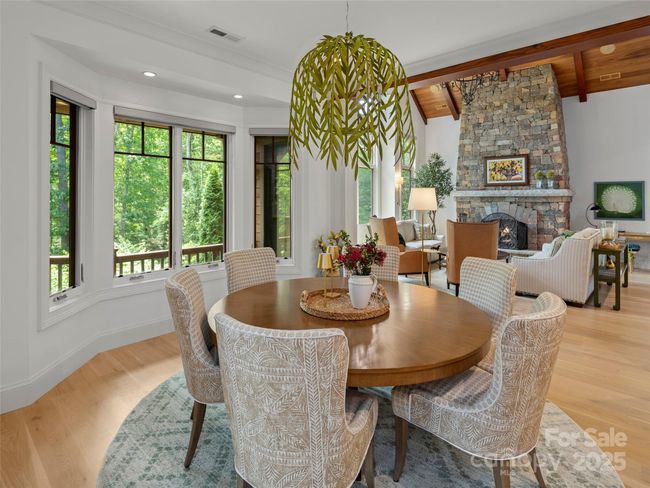 Bank of windows provide views of the lush landscaping and allow in abundant light. Stray Dog Designs "Willow" chandelier over dining table. | Image 13