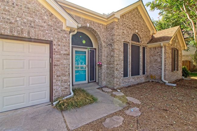 Doorway to property with a garage and brick siding | Image 4