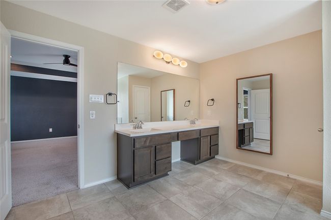 Bathroom with double vanity, ceiling fan, and tile patterned flooring | Image 23