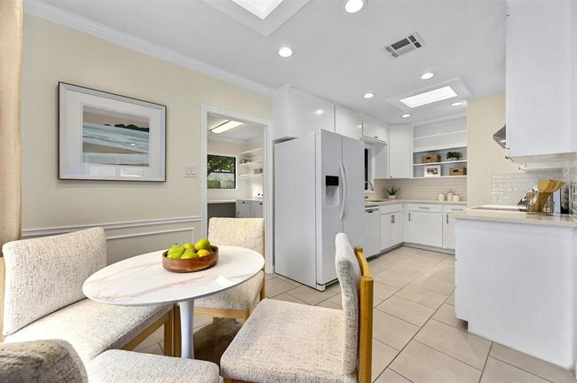 Dining space featuring ornamental molding, light tile patterned floors, a skylight, and recessed lighting | Image 7
