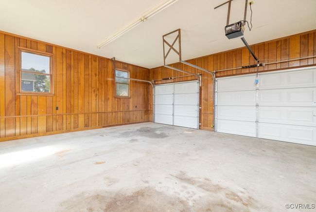 Garage featuring a garage door opener and wooden walls | Image 21