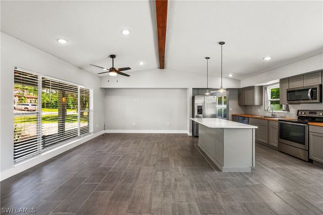 Kitchen featuring lofted ceiling with beams, sink, appliances with stainless steel finishes, and wood-type flooring | Image 18