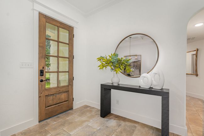 Foyer with arched walkways, crown molding, and light stone finish floors | Image 4