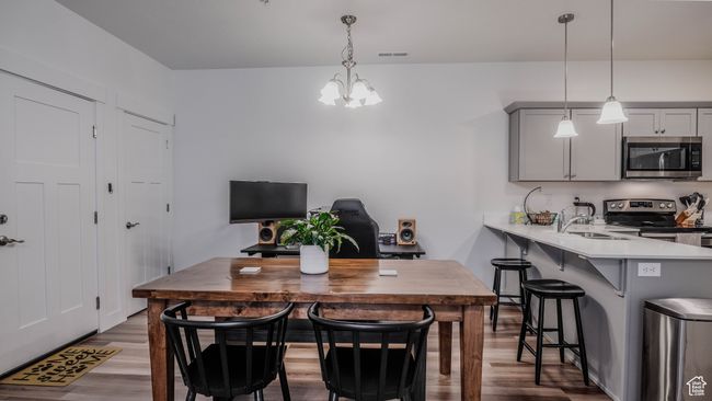 Dining area with wood finished floors and an inviting chandelier | Image 9