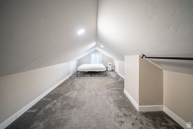 Bedroom featuring vaulted ceiling, carpet flooring, and a textured wall | Image 17