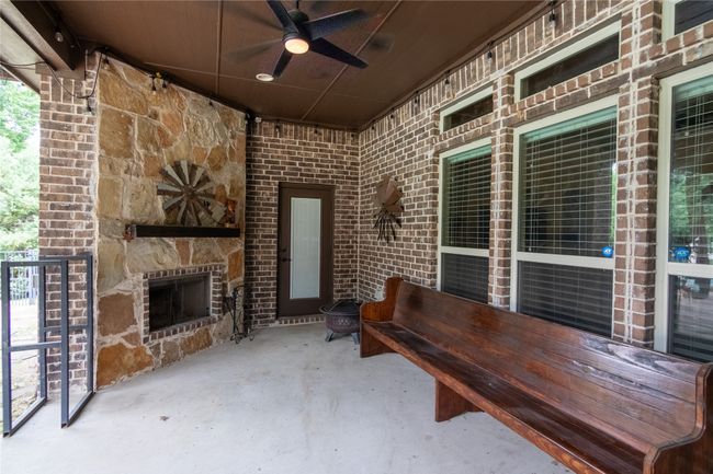 View of patio / terrace featuring an outdoor stone fireplace and ceiling fan | Image 32