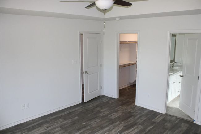 Unfurnished bedroom featuring dark wood finished floors, a spacious closet, and a ceiling fan | Image 7