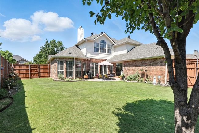 Back of house with brick siding, a patio area, a fenced backyard, and a shingled roof | Image 31