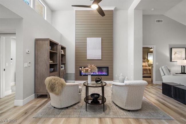 Inside you'll discover soaring majestic ceilings, an open-concept floor plan, sleek pocket windows, & warm natural light. The upgraded interior features luxury flooring, fresh designer paint, & new baseboards. Relax by the linear fireplace or entertain in the formal dining area. | Image 5