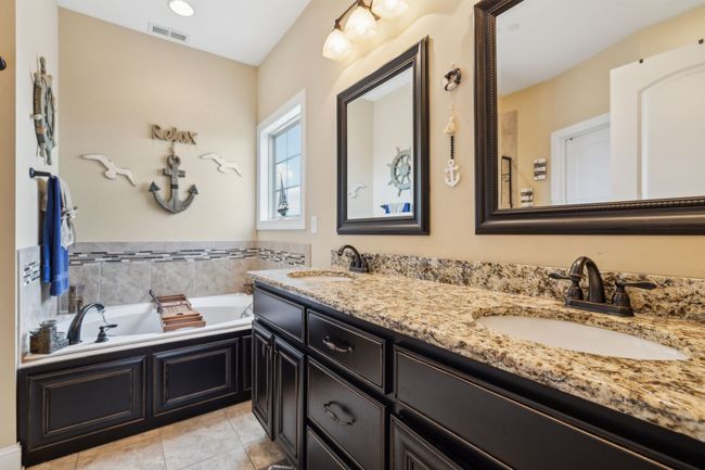 The primary bathroom features elegant tile flooring and double vanities, offering plenty of space for daily routines. 1107 Sycamore Leaf Way Murfreesboro, TN 37129 | Image 19