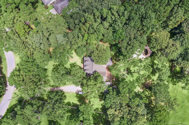 Charming two-story home with a welcoming front porch, nestled among mature trees. Features dormer windows, a classic gable roof, and a spacious yard, perfect for enjoying nature and outdoor activities. | Image 17