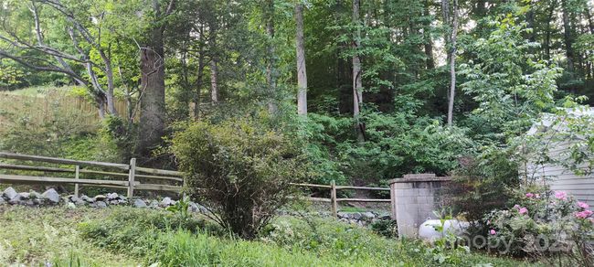 split rail fencing borders the driveway entry | Image 10