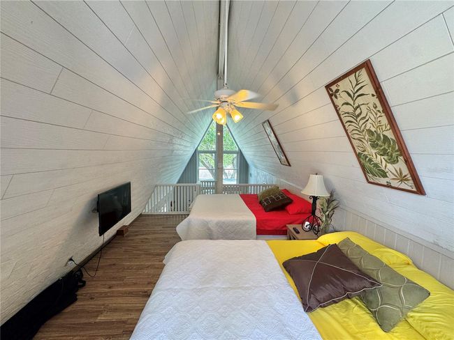 Spiral staircase to Loft bedroom with 2 beds and opens to outside balcony porch. | Image 27