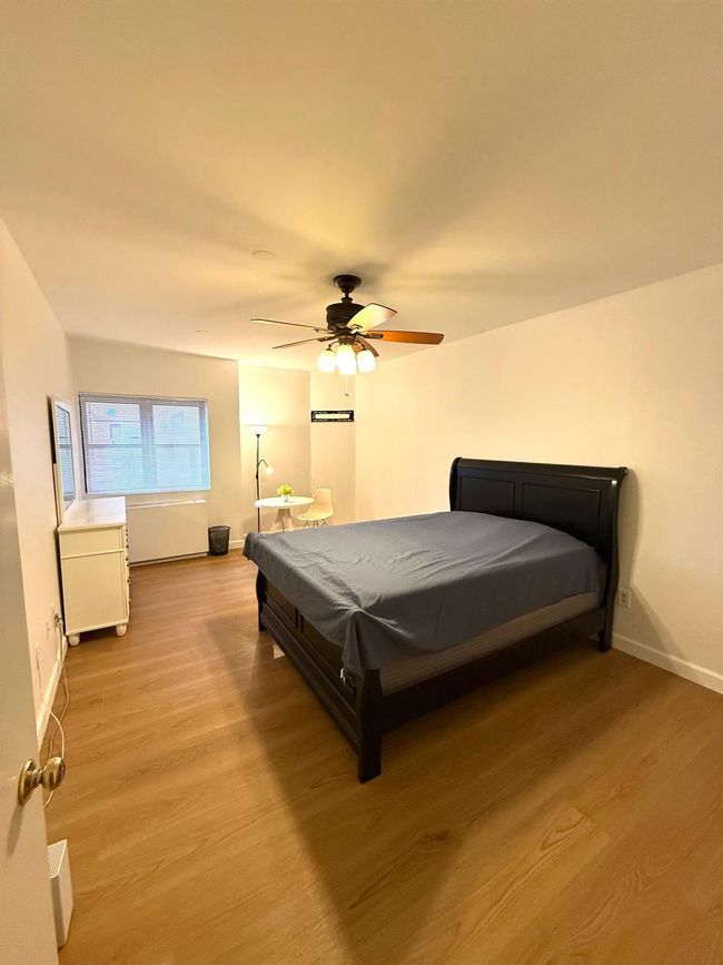 Bedroom featuring a ceiling fan, light wood finished floors, and baseboards | Image 4