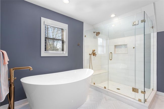 Full bathroom featuring a wealth of natural light, a stall shower, a soaking tub, and recessed lighting | Image 10