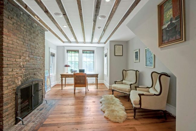 Living area with light wood finished floors, a brick fireplace, baseboards, an office area, and recessed lighting | Image 17