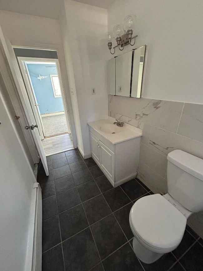 Bathroom featuring tile walls, vanity, and toilet | Image 13
