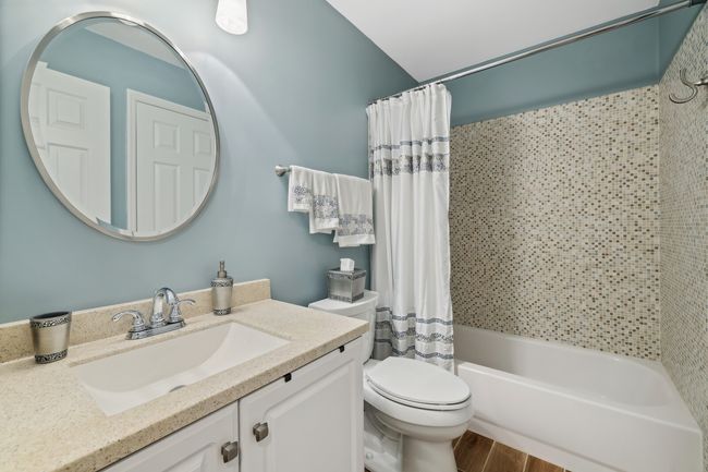 Main bath in hall has granite countertop and a tiled tub surround, and is directly accessible from Bedroom 3. | Image 32
