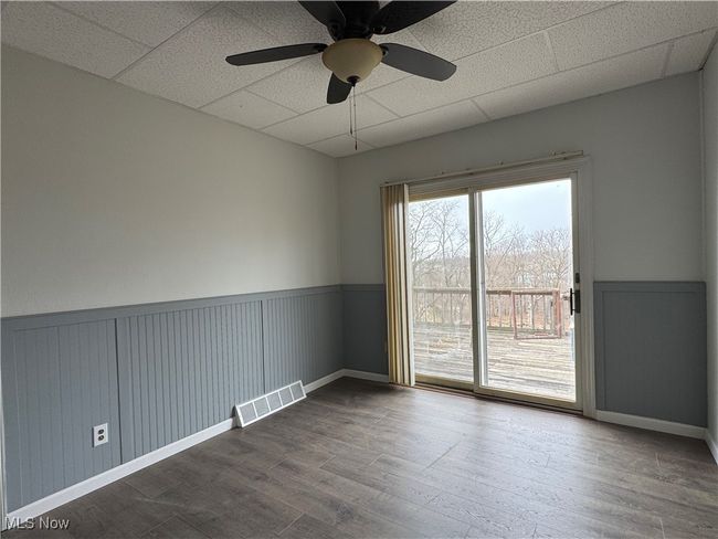 Empty room featuring hardwood / wood-style flooring, a paneled ceiling, and ceiling fan | Image 6