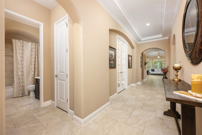 Hall featuring arched walkways, crown molding, and french doors | Image 9